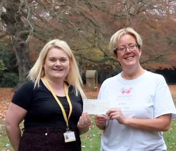 Lizzie Badger (right) hands over a cheque to Compton Care (Hospice) from 2021 PTM merchandise sales